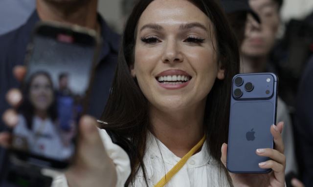 নতুন আইফোন দিয়ে নিজের ভিডিও করছেন এক সম্ভাব্য ক্রেতা। ছবি: এএফপি