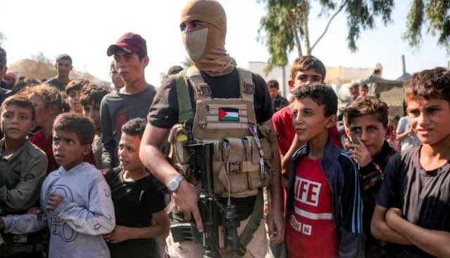 গাজায় হামাসের এক সশস্ত্র সদস্যকে ঘিরে শিশুরা। ছবি: এএফপি