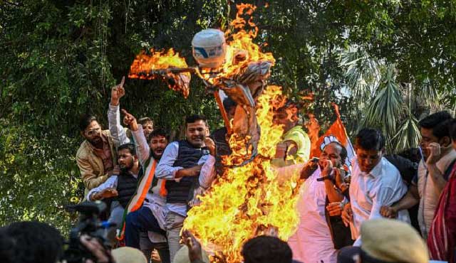 কংগ্রেসের যুব শাখার সদস্যরা দিল্লিতে ট্রাম্পের কুশপুত্তলিকা দাহ করেন। ছবি: রয়টার্স
