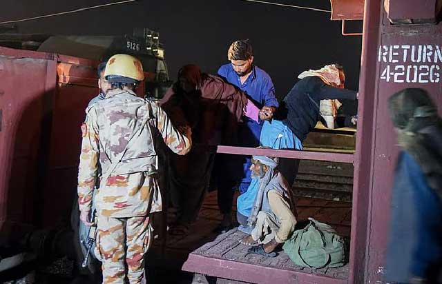 পাকিস্তানে জিম্মি করা ট্রেনের এক যাত্রীকে সহায়তা করছেন একজন সেনা। ১১ মার্চ, বেলুচিস্তানের মাচ রেলওয়ে স্টেশনে। ছবি: এএফপি